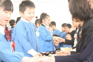 園長先生と握手を交わす園児の画像
